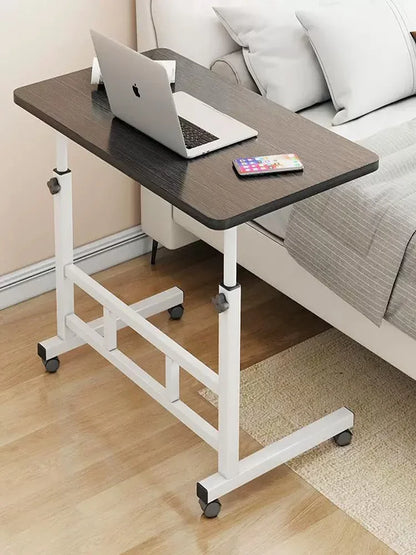 Adjustable laptop desk in a living room setting with a laptop and remote control on it.