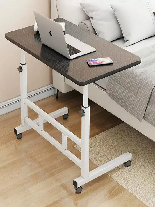 Adjustable laptop desk in a living room setting with a laptop and remote control on it.
