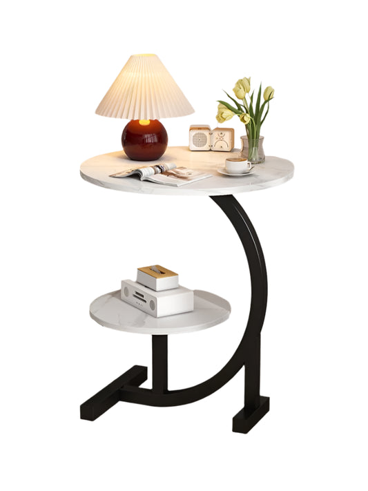 Small round table with marble top and black curved legs in a corner setting.
