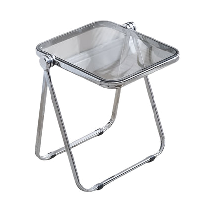 Chrome folding stool on a carpeted floor with a plant in the background