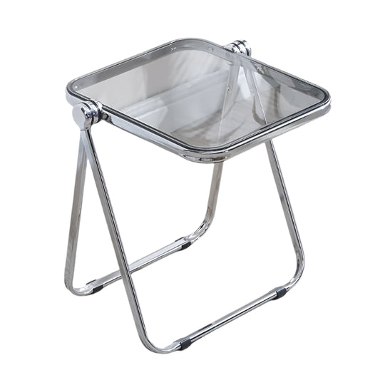 Chrome folding stool on a carpeted floor with a plant in the background